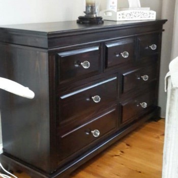 Large dark stained solid wood chest of drawers with ornate glass handles