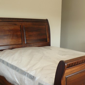 Solid stained wood bed showing detailing